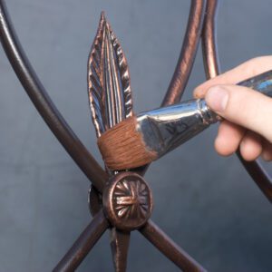 Hand painting bronze leaf on metalwork
