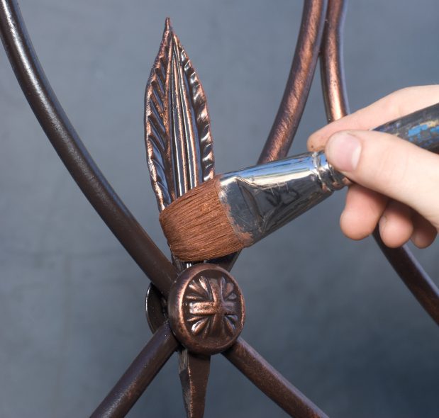 Hand painting bronze leaf on metalwork